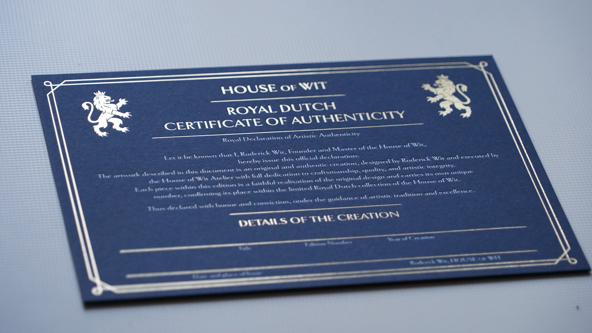 House of Wit Certificate of Authenticity photographed from a lower-left angle, showing the official artwork certification and edition details.