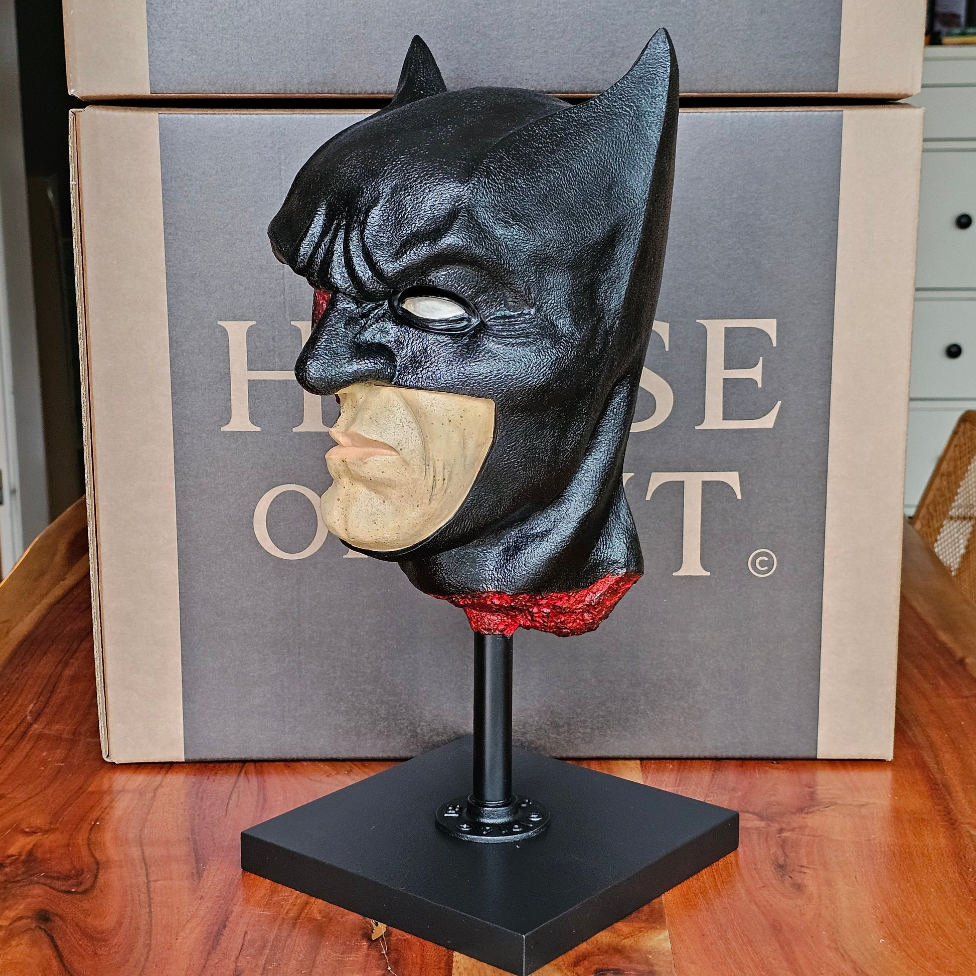 “Back view of Batman anatomical bust displaying smooth black cowl and sculpted neck on a black stand.”

