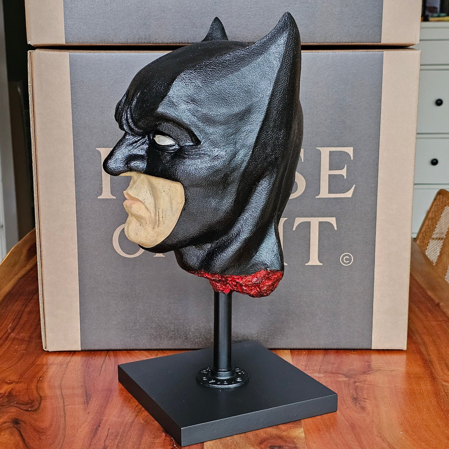 “Batman anatomical bust from back-left angle, smooth black cowl and blood-red neck detail on stand.”

